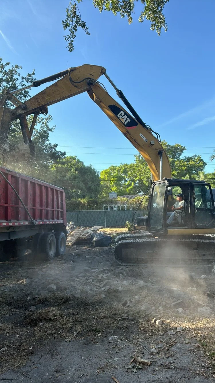 Excavator loading debris during a complete demolition
